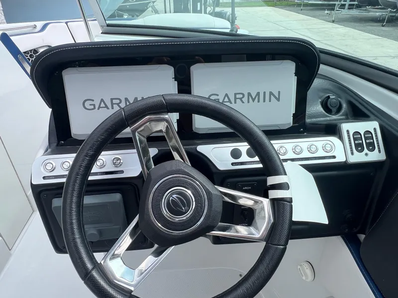 Slide: The Image of 2024 Crownline 270 XSS boat dashboard with Garmin navigation screens and steering wheel. - 11