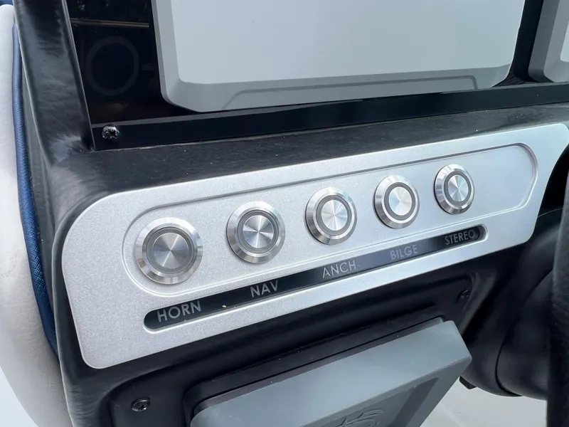 Slide: The Image of 2024 Crownline 270 XSS boat control panel with buttons for horn, navigation, anchor, bilge, and stereo. - 13