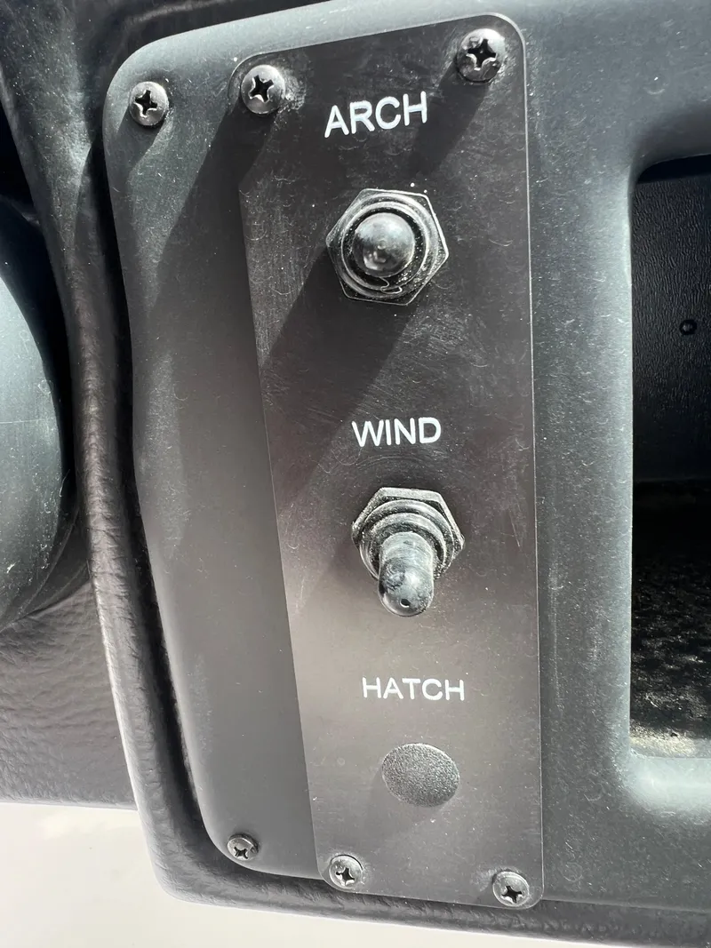 Slide: The Image of Control panel of 2024 Crownline 270 XSS boat with arch, wind, and hatch switches. - 24