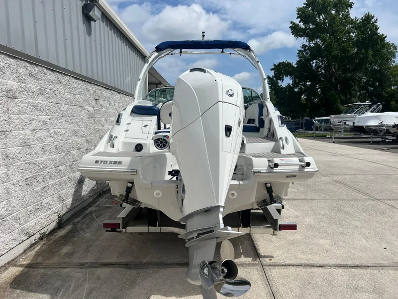 Slide: The Image of 2024 Crownline 270 XSS boat with outboard motor, docked outdoors. - 6