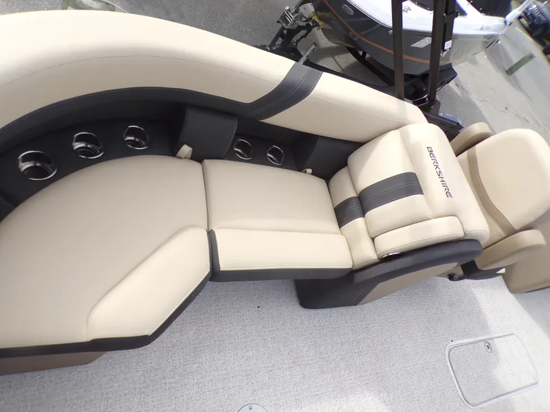 Slide: The Image of 2024 Berkshire 22RFX CTS pontoon boat with black canopy and motor, parked outdoors. - 15
