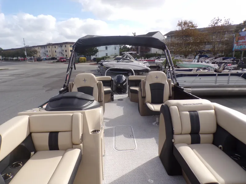 Slide: The Image of 2024 Berkshire 22RFX CTS pontoon boat with Mercury engine and canopy, parked outdoors. - 5