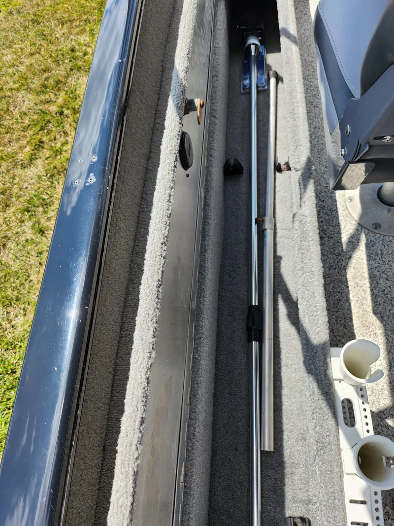 Slide: The Image of 2013 Tracker Super Guide V-16 SC boat interior with fishing rod storage. - 11