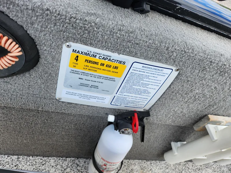 Slide: The Image of 2013 Tracker Super Guide V-16 SC boat capacity label and fire extinguisher. - 12
