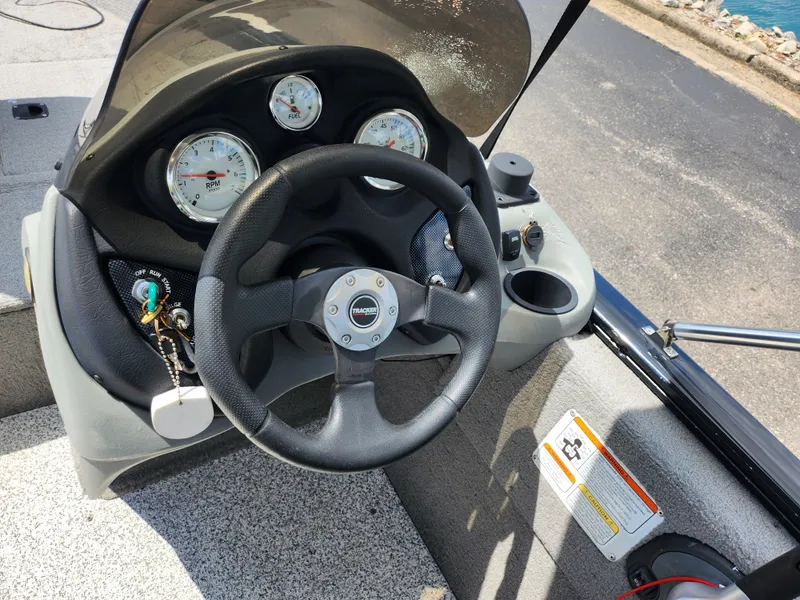 Slide: The Image of 2013 Tracker Super Guide V-16 SC boat dashboard with steering wheel and gauges. - 13