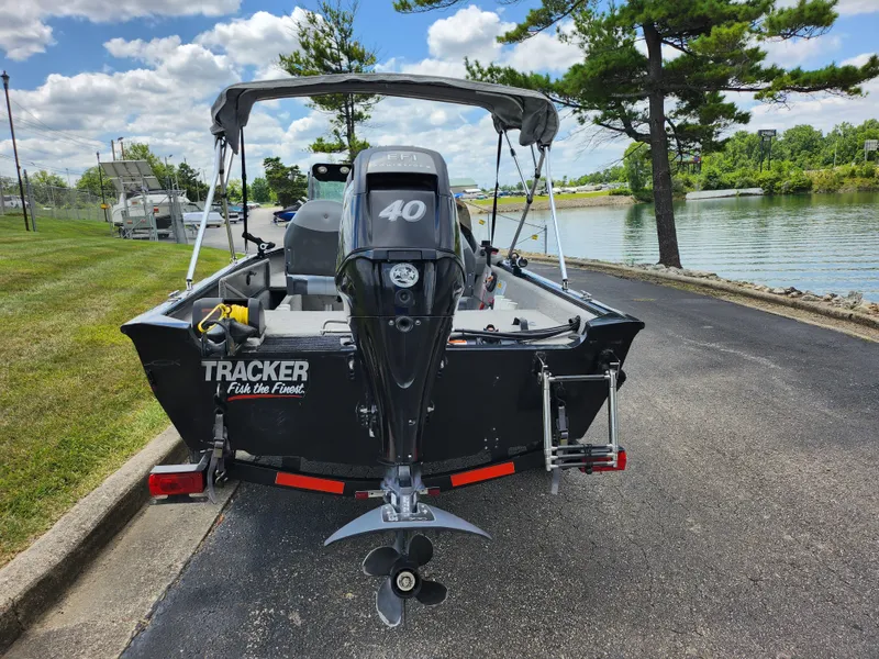 Slide: The Image of 2013 Tracker Super Guide V-16 SC fishing boat with 40 HP motor by a lake. - 2