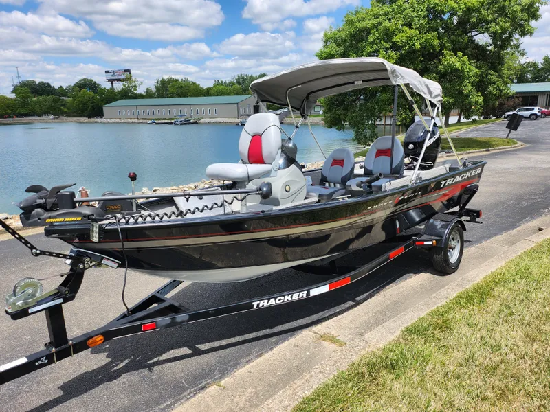 Slide: The Image of 2013 Tracker Super Guide V-16 SC fishing boat on trailer by a lake. - 8