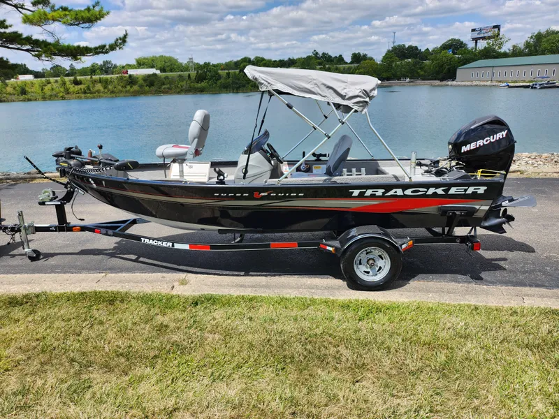 Slide: The Image of 2013 Tracker Super Guide V-16 SC fishing boat on trailer by a lake. - 9