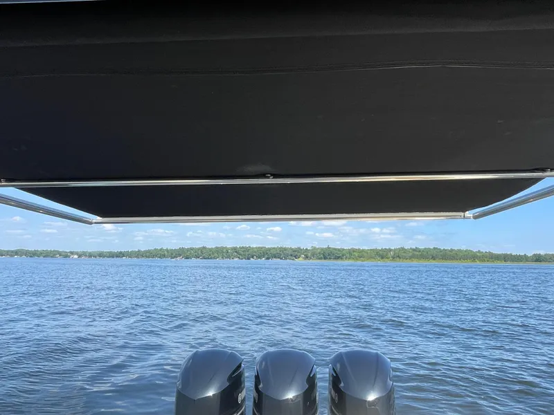Slide: The Image of Chris-Craft Catalina 34 (2019) with triple outboard motors on a serene lake. - 11