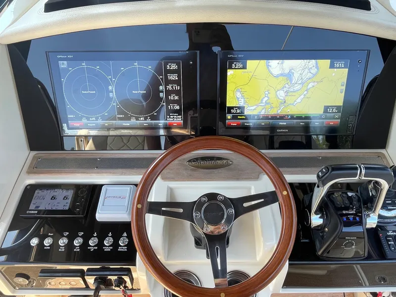 Slide: The Image of 2019 Chris-Craft Catalina 34 helm with dual navigation screens and wooden steering wheel. - 22