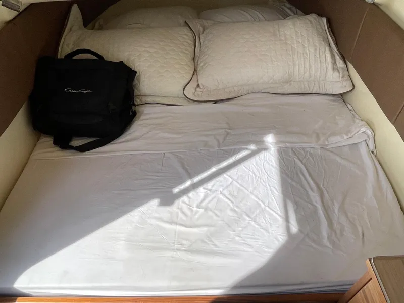Slide: The Image of 2019 Chris-Craft Catalina 34 cabin bed with pillows and a black bag. - 24