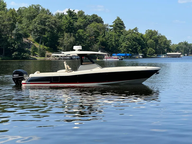 Slide: The Image of 2019 Chris-Craft Catalina 34 boat on a serene lake with lush green trees. - 7