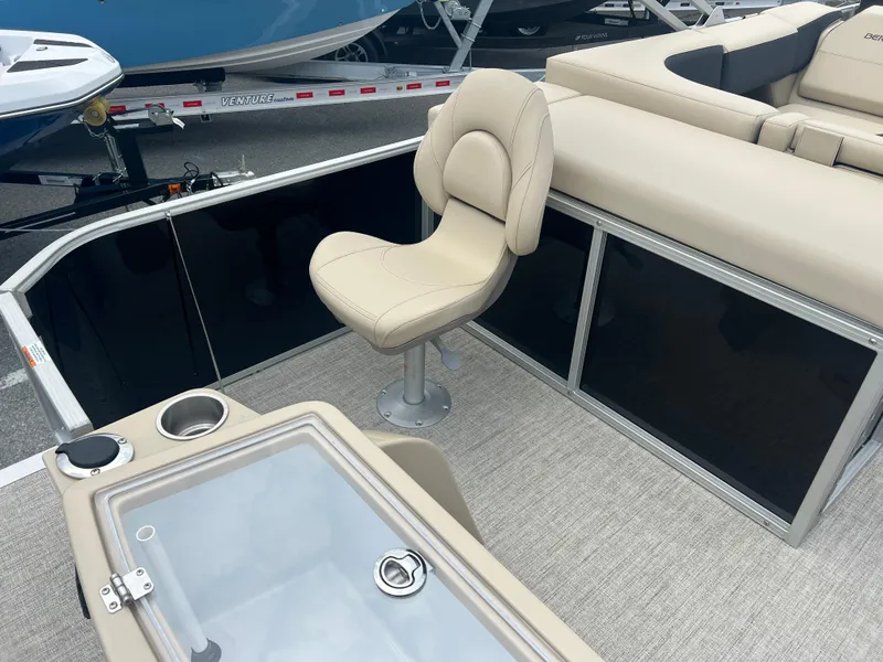 Slide: The Image of 2024 Berkshire 23RFC STS 2.75 boat interior with beige seating and storage compartments. - 15