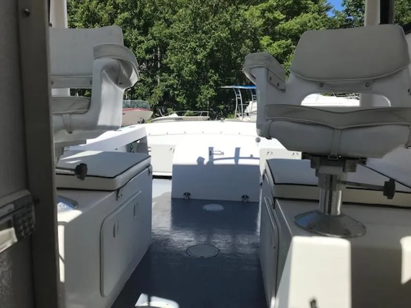 Slide: The Image of 2003 Eastern 27' Lobster boat interior with white seating and storage compartments. - 13