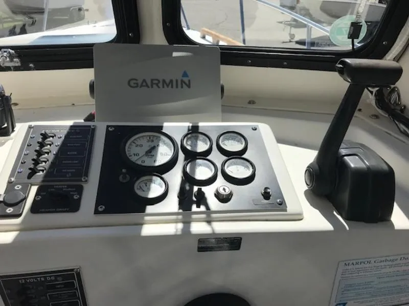Slide: The Image of 2003 Eastern 27' Lobster boat dashboard with Garmin navigation system and control panel. - 18