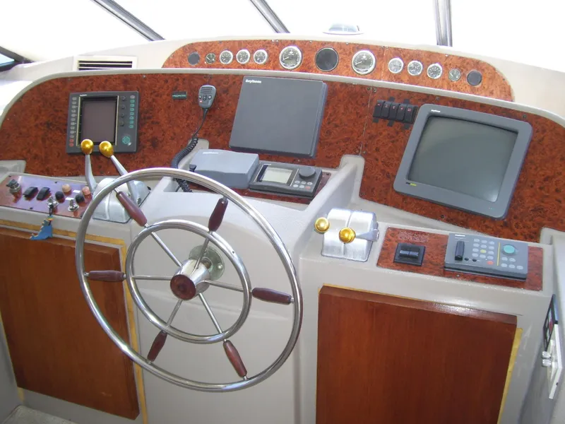 Slide: The Image of 1999 Bayliner 5788 Pilot House Motoryacht helm with steering wheel and navigation instruments. - 14