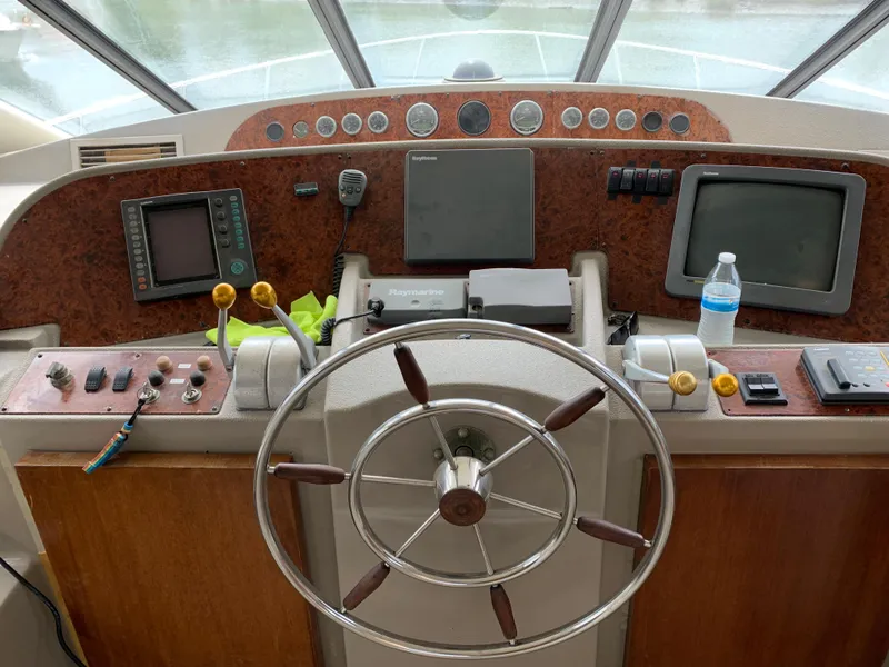 Slide: The Image of 1999 Bayliner 5788 Pilot House Motoryacht helm with steering wheel and navigation equipment. - 15