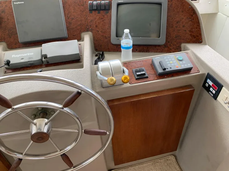 Slide: The Image of 1999 Bayliner 5788 Pilot House Motoryacht helm with steering wheel and navigation controls. - 19