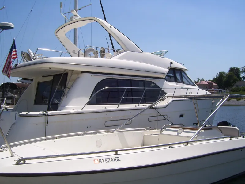 Slide: The Image of 1999 Bayliner 5788 Pilot House Motoryacht docked, featuring sleek design and spacious deck. - 2