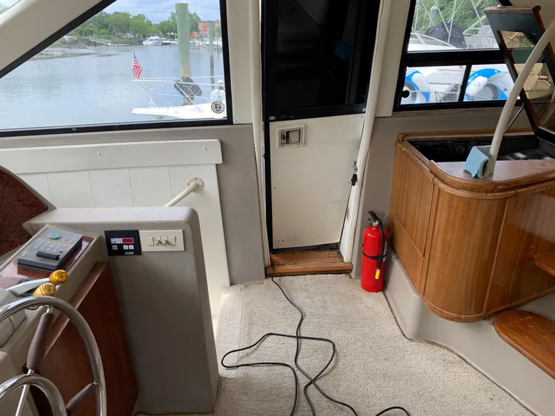 Slide: The Image of 1999 Bayliner 5788 Pilot House Motoryacht interior with helm, stairs, and fire extinguisher. - 22