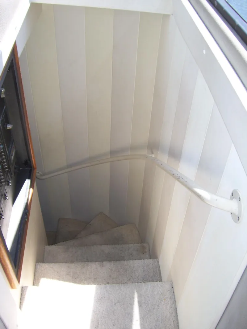 Slide: The Image of Staircase inside 1999 Bayliner 5788 Pilot House Motoryacht with white paneling and carpeted steps. - 23