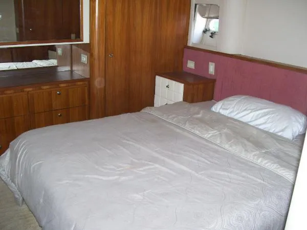 Slide: The Image of Bedroom interior of 1999 Bayliner 5788 Pilot House Motoryacht with wooden cabinetry and cozy bed. - 24