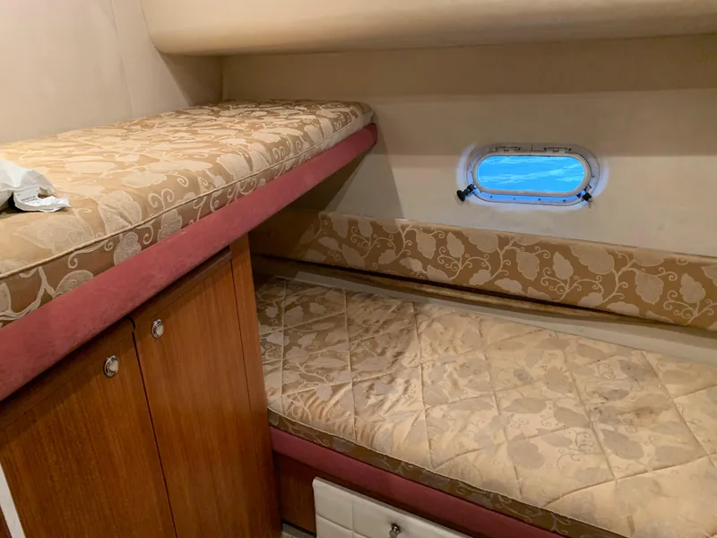 Slide: The Image of 1999 Bayliner 5788 Pilot House Motoryacht cabin with bunk beds and porthole view. - 25