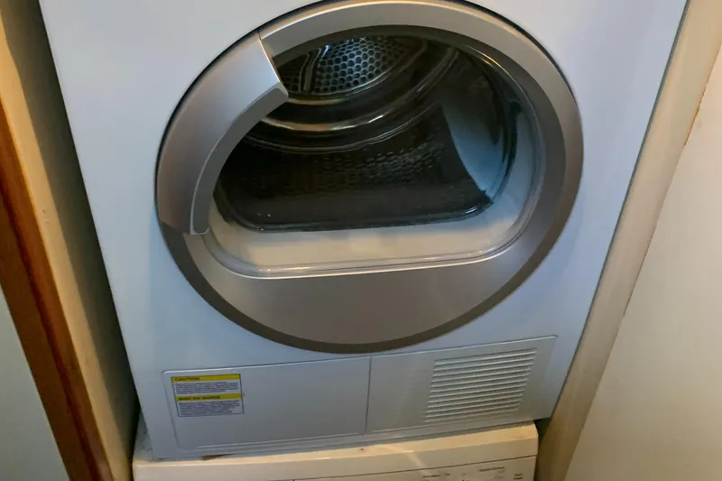 Slide: The Image of Front-loading washing machine in a compact laundry space on a 1999 Bayliner 5788 Pilot House Motoryacht. - 30