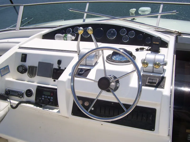 Slide: The Image of 1999 Bayliner 5788 Pilot House Motoryacht helm with steering wheel and control panel. - 31