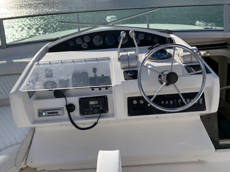 Slide: The Image of 1999 Bayliner 5788 Pilot House Motoryacht helm with steering wheel and control panel. - 32