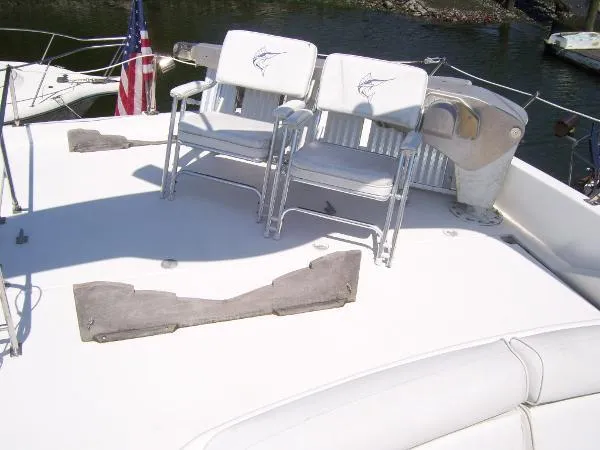 Slide: The Image of 1999 Bayliner 5788 Pilot House Motoryacht deck with chairs and American flag. - 38