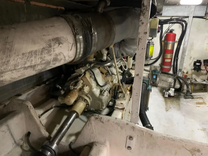 Slide: The Image of Engine room of 1999 Bayliner 5788 Pilot House Motoryacht, showing mechanical components and fire extinguisher. - 49