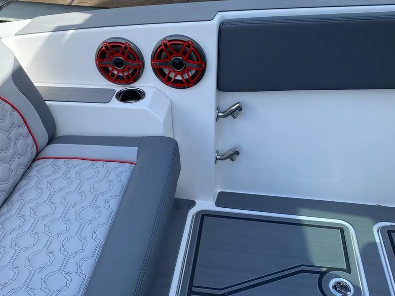 Slide: The Image of 2025 Fountain 38 SCX boat interior with gray seating, red speakers, and a central table. - 14