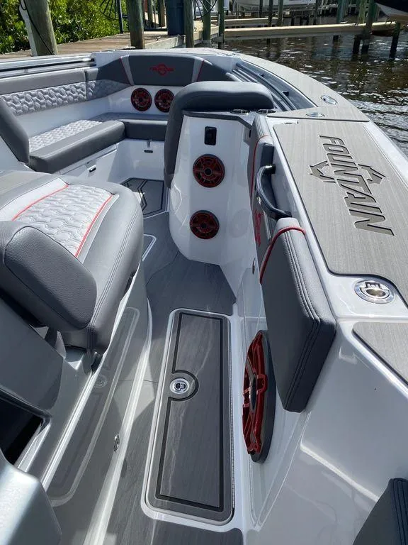 Slide: The Image of 2025 Fountain 38 SCX boat cruising on a calm river with a bridge in the background. - 2