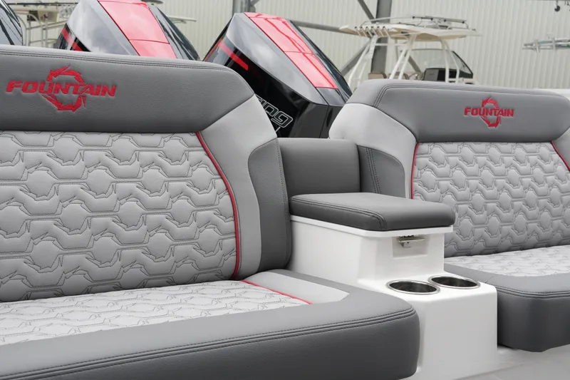 Slide: The Image of 2025 Fountain 38 SCX boat interior with gray and red seating, featuring cup holders. - 36