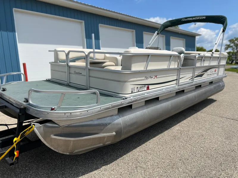 Slide: The Image of 2006 Sun Tracker PB 24 pontoon boat with green canopy and white seating. - 21