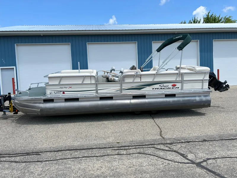 Slide: The Image of 2006 Sun Tracker PB 24 pontoon boat parked near blue storage units. - 22