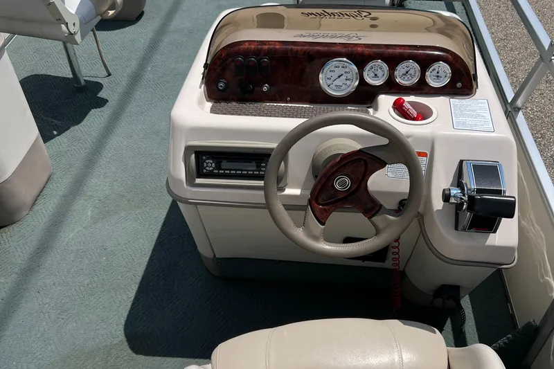 Slide: The Image of 2006 Sun Tracker PB 24 boat dashboard with steering wheel and instrument panel. - 23