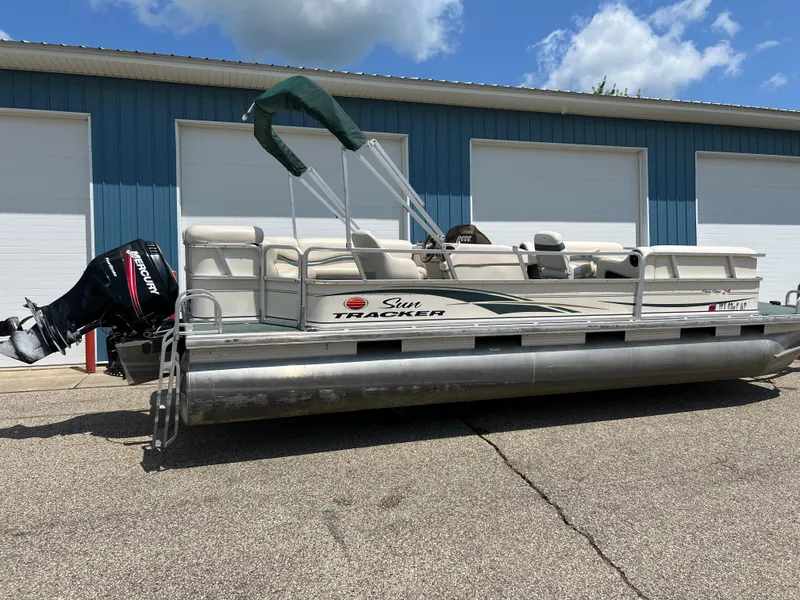 Slide: The Image of 2006 Sun Tracker PB 24 pontoon boat parked outside blue garage. - 3
