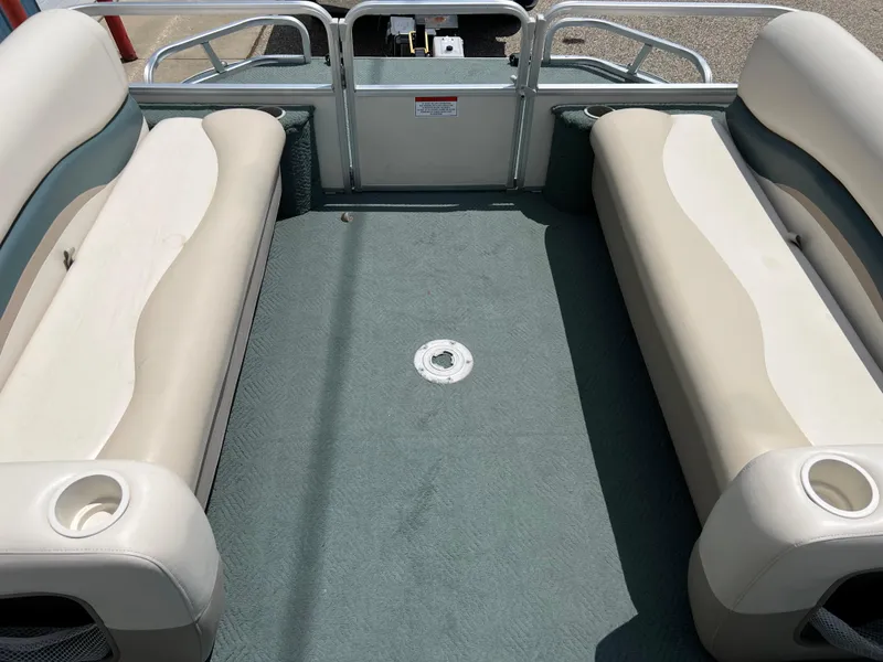 Slide: The Image of 2006 Sun Tracker PB 24 pontoon boat interior with beige seating and green carpet. - 8