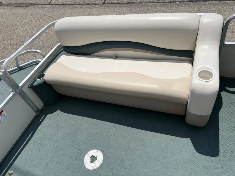 Slide: The Image of 2006 Sun Tracker PB 24 boat seat with cup holder and green flooring. - 9