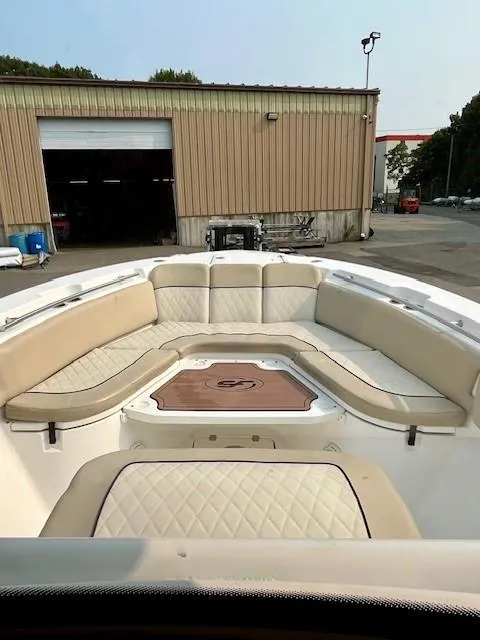 Slide: The Image of 2018 Sea Fox 288 Commander boat with spacious seating and storage, docked near a warehouse. - 14