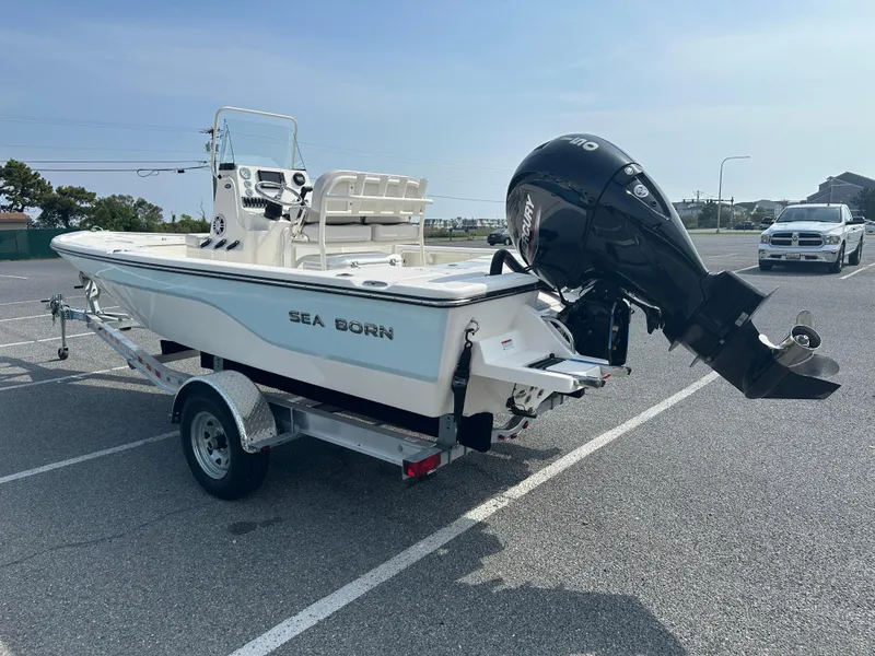 Slide: The Image of 2024 Sea Born FX21 Bay LT boat on trailer with outboard motor in parking lot. - 4