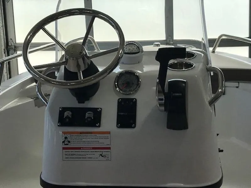 Slide: The Image of 2025 Edgewater 158 CS boat console with steering wheel and controls. - 12