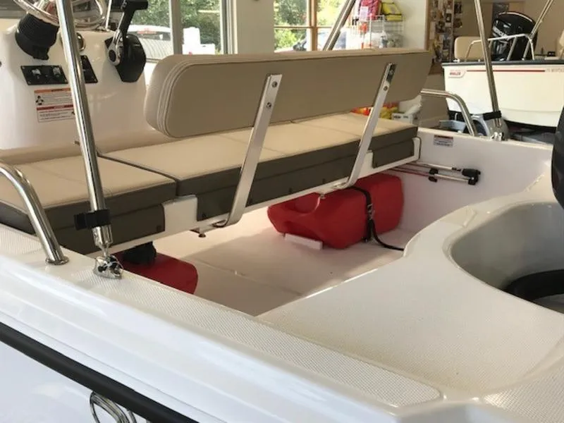 Slide: The Image of 2025 Edgewater 158 CS boat interior with beige seating and red fuel tanks. - 3