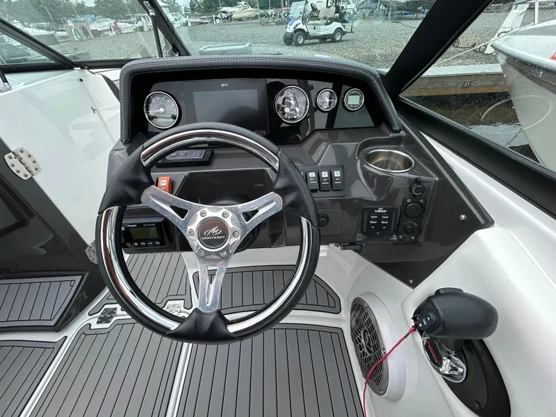 Slide: The Image of 2021 Monterey M65 boat dashboard with steering wheel and control panel. - 19