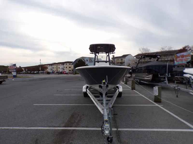Slide: The Image of 2024 Sea Born LX24 Center Console LE boat on a trailer in a parking lot. - 2