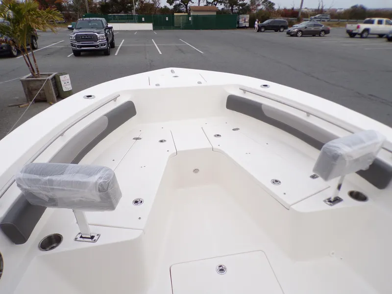 Slide: The Image of 2024 Sea Born LX24 Center Console LE boat with spacious seating in a parking lot. - 6