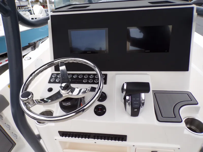 Slide: The Image of 2024 Sea Born LX24 Center Console LE helm with dual screens and stainless steel steering wheel. - 9