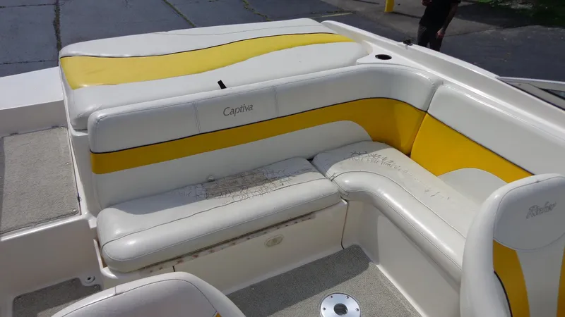 Slide: The Image of 2002 Rinker 212 Captiva Bowrider interior seating with yellow and white upholstery. - 17